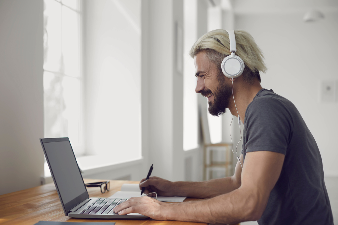 Education Learning Study Online Video Call Chat. Male Student Smiling Is Studying an Online Lesson with a Teacher Using a Laptop Webcam at Home.